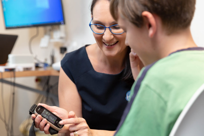boy with audiologist showing latest technology boy with audiologist showing latest technology