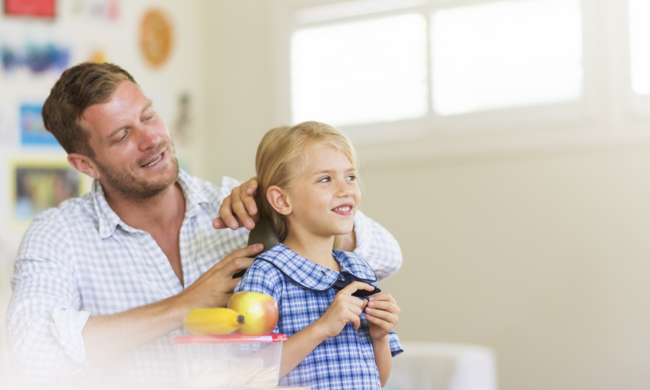 father getting daughter ready for school