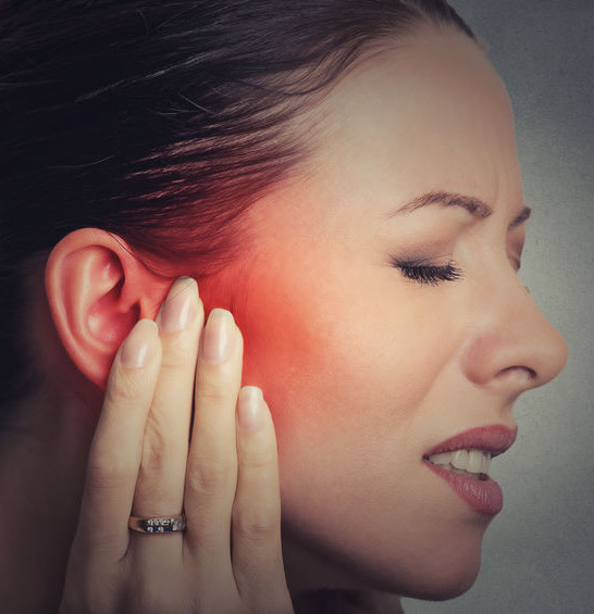 woman has hand on ear ringing tinnitus woman has hand on ear ringing tinnitus